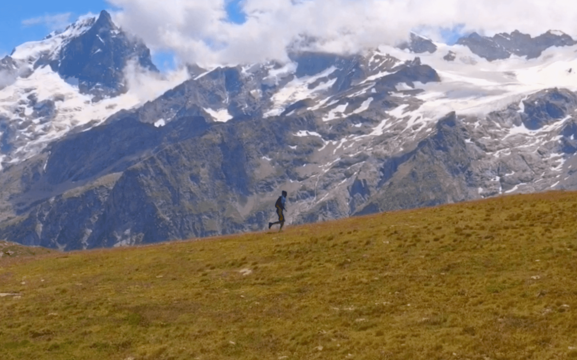 Image prise par drone de Yannis Turlais courant devant une chaine de montagne dans le massif des Écrins